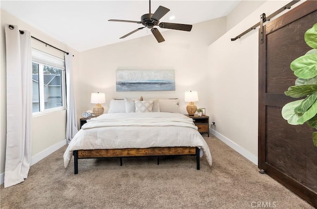 bedroom featuring carpet flooring, a barn door, baseboards, lofted ceiling, and a ceiling fan
