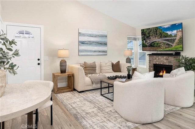 living room with lofted ceiling, wood finished floors, and a fireplace
