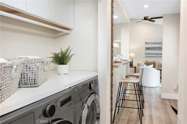 laundry room featuring washing machine and dryer, recessed lighting, light wood-style floors, ceiling fan, and cabinet space