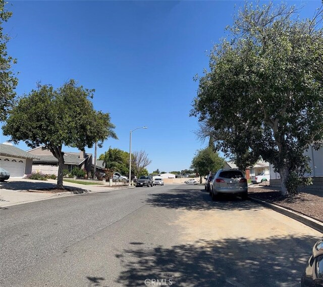 view of street with street lighting, curbs, sidewalks, and a residential view