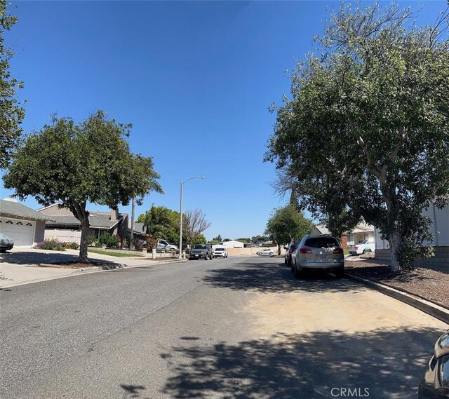 1387 Dyer Way, Corona, CA 92882 - view of asphalt road with curbs, sidewalks, a residential view, and street lighting