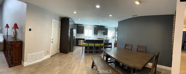dining room with light wood-style floors, recessed lighting, and baseboards