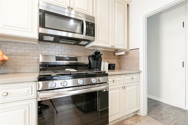 10444 Flowerdale Ct, Sun Valley, CA 91352 - kitchen featuring light wood-style flooring, decorative backsplash, light countertops, and stainless steel appliances