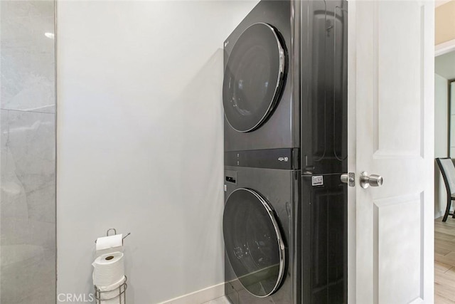 10444 Flowerdale Ct, Sun Valley, CA 91352 - clothes washing area featuring baseboards, wood finished floors, stacked washing maching and dryer, and laundry area