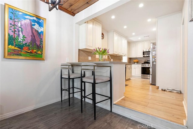 10444 Flowerdale Ct, Sun Valley, CA 91352 - kitchen featuring light wood-style floors, tasteful backsplash, a peninsula, recessed lighting, and appliances with stainless steel finishes