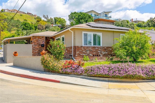 10444 Flowerdale Ct, Sun Valley, CA 91352 - view of property exterior with brick siding, stucco siding, and roof mounted solar panels