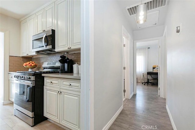 10444 Flowerdale Ct, Sun Valley, CA 91352 - kitchen with decorative backsplash, light wood-type flooring, baseboards, and stainless steel appliances