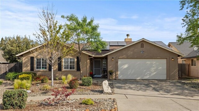 11 Maddie Ct, Chico, CA 95973 - ranch-style home featuring concrete driveway, stucco siding, an attached garage, fence, and roof mounted solar panels