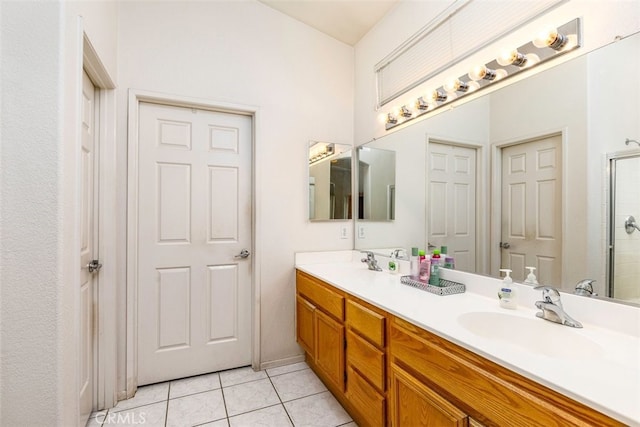 bathroom featuring tile patterned flooring, a sink, an enclosed shower, and double vanity