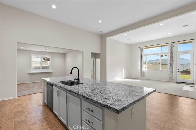 kitchen featuring a healthy amount of sunlight, light colored carpet, a sink, and stainless steel dishwasher