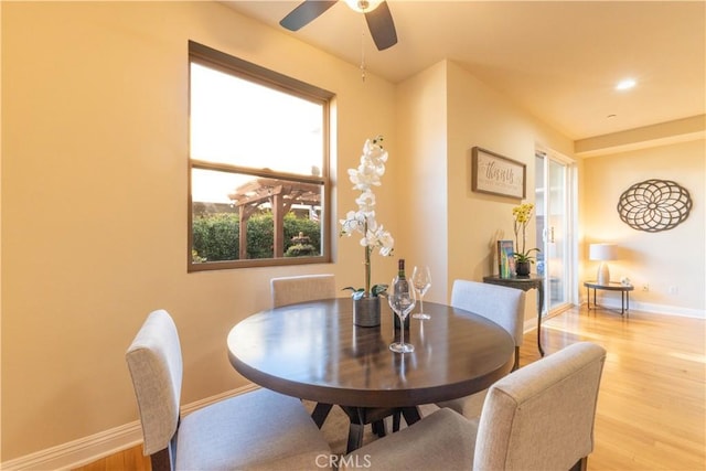 dining room with light wood-style flooring, baseboards, and ceiling fan
