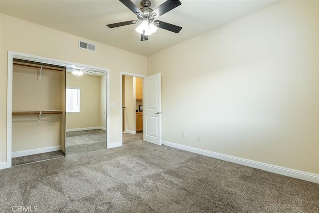 unfurnished bedroom featuring a closet, baseboards, a ceiling fan, visible vents, and carpet