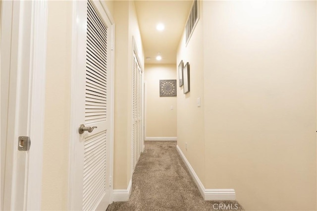 hall featuring carpet flooring, baseboards, visible vents, and recessed lighting