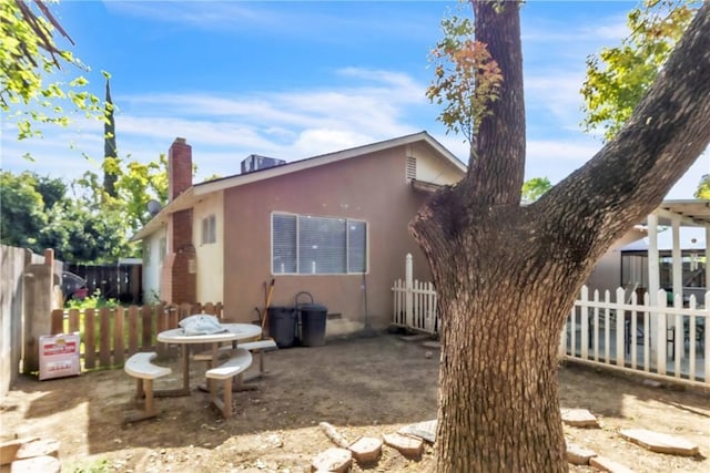 2855 Pira Dr, Merced, CA 95348 - back of house featuring a patio area, stucco siding, fence, and a chimney