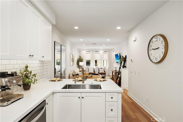 59 Sanctuary Ln, Mission Viejo, CA 92692 - kitchen with a peninsula, white cabinets, decorative backsplash, stainless steel dishwasher, and a sink