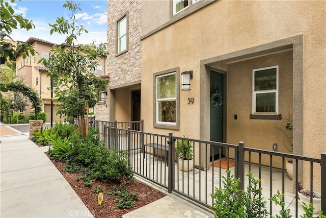 59 Sanctuary Ln, Mission Viejo, CA 92692 - property entrance featuring stucco siding, stone siding, and fence