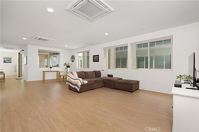 living area featuring visible vents, light wood-type flooring, and recessed lighting