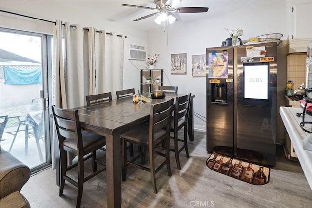 dining room featuring a wall mounted AC, wood finished floors, and ceiling fan