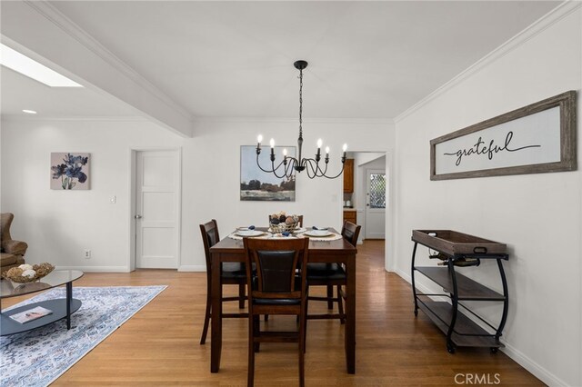 1492 Coolidge Ave, Pasadena, CA 91104 - dining space featuring crown molding, wood finished floors, an inviting chandelier, and baseboards