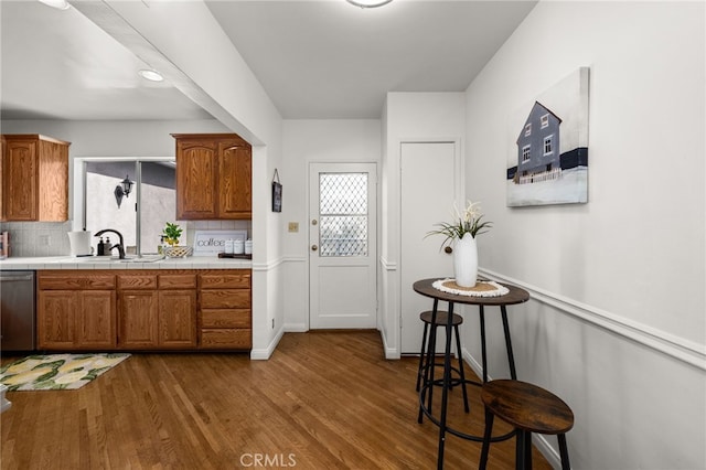 1492 Coolidge Ave, Pasadena, CA 91104 - kitchen featuring dishwasher, brown cabinets, decorative backsplash, and wood finished floors