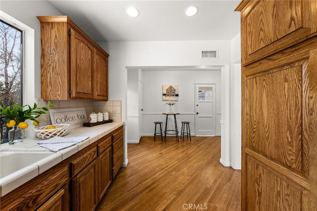 1492 Coolidge Ave, Pasadena, CA 91104 - kitchen with light wood-type flooring, visible vents, recessed lighting, tile counters, and backsplash