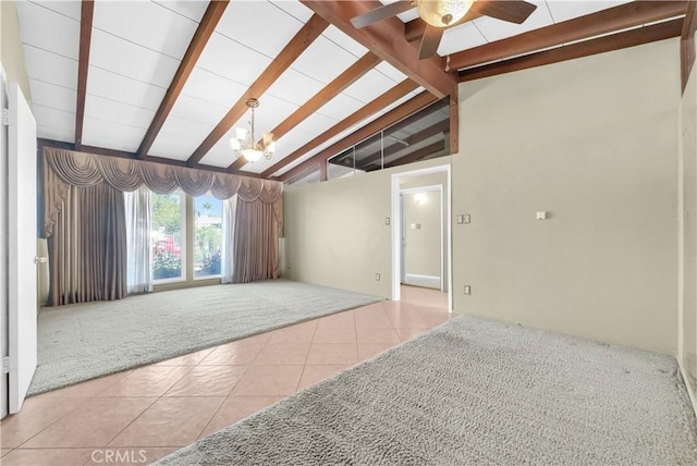 tiled spare room featuring carpet floors, lofted ceiling with beams, and ceiling fan with notable chandelier