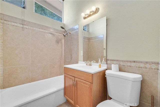 full bathroom featuring tile walls, wainscoting, vanity, toilet, and tub / shower combination