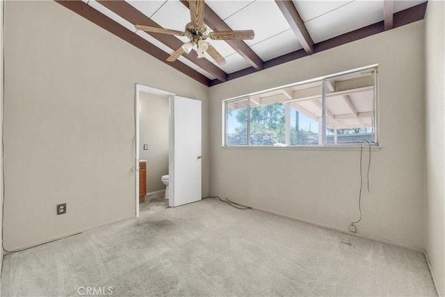 unfurnished bedroom featuring lofted ceiling with beams, carpet flooring, and ensuite bath