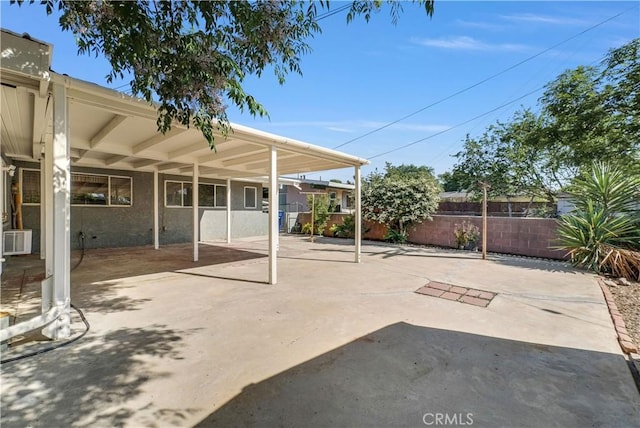 view of patio featuring fence and a carport