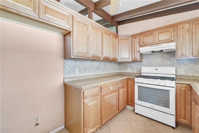 kitchen featuring light brown cabinetry, tasteful backsplash, light countertops, white gas range oven, and under cabinet range hood