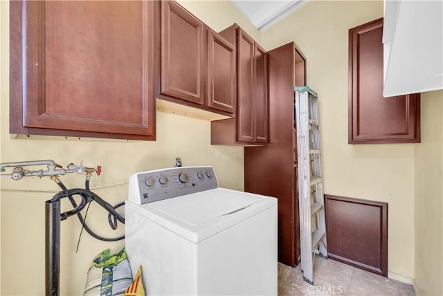 clothes washing area featuring light tile patterned floors, cabinet space, and washer / clothes dryer