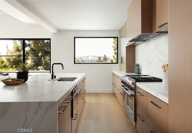 3 Rue Valbonne, Newport Beach, CA 92660 - kitchen featuring wall chimney exhaust hood, modern cabinets, a sink, light wood-style flooring, and light stone counters