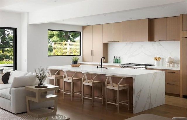 3 Rue Valbonne, Newport Beach, CA 92660 - kitchen featuring light countertops, a kitchen island with sink, wood finished floors, stove, and backsplash