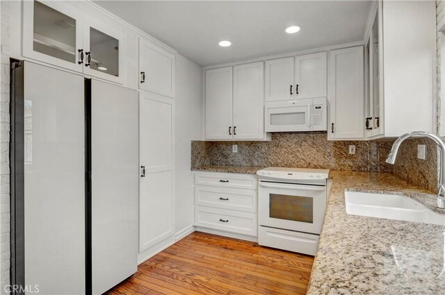 7200 Newton Way, Stanton, CA 90680 - kitchen featuring white cabinetry, decorative backsplash, a sink, and white appliances