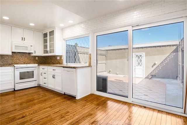 7200 Newton Way, Stanton, CA 90680 - kitchen with stone countertops, hardwood / wood-style flooring, white appliances, white cabinetry, and backsplash
