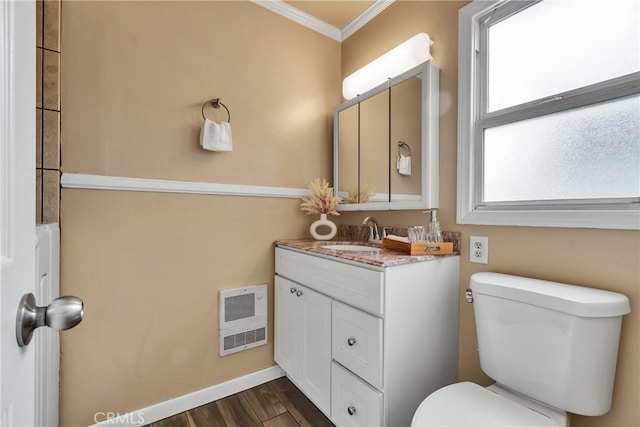 bathroom with toilet, wood finished floors, vanity, crown molding, and heating unit