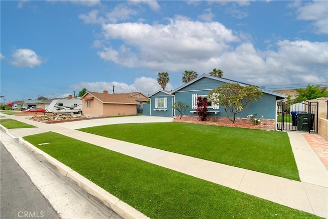 view of front of home featuring a gate, a front lawn, and driveway