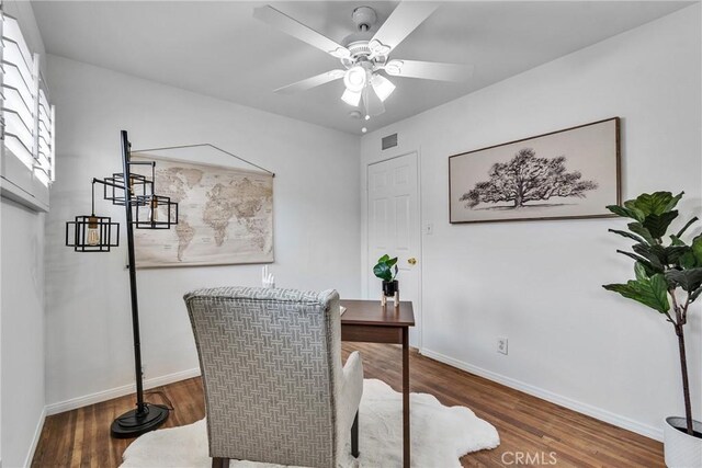 office space with wood finished floors, visible vents, baseboards, and a ceiling fan