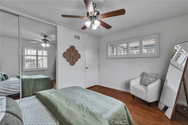 bedroom with a closet, visible vents, wood finished floors, and ceiling fan