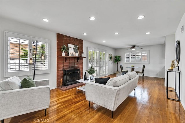 living area with baseboards, wood finished floors, and a ceiling fan