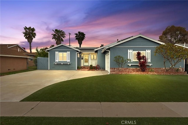 ranch-style house featuring concrete driveway, a yard, stucco siding, and fence