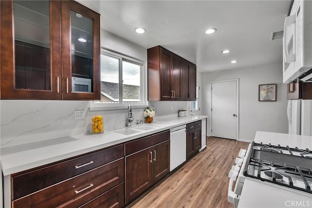 kitchen with white appliances, visible vents, a sink, light countertops, and light wood-type flooring