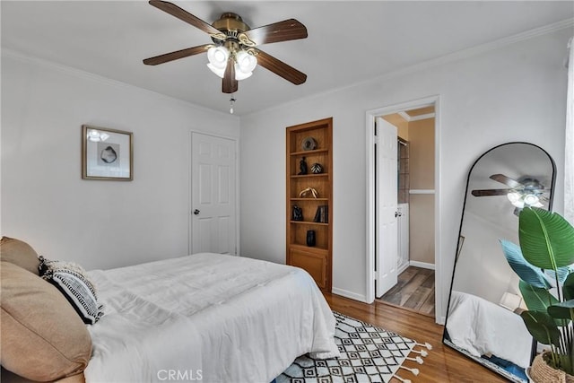 bedroom featuring ornamental molding, baseboards, a ceiling fan, and wood finished floors
