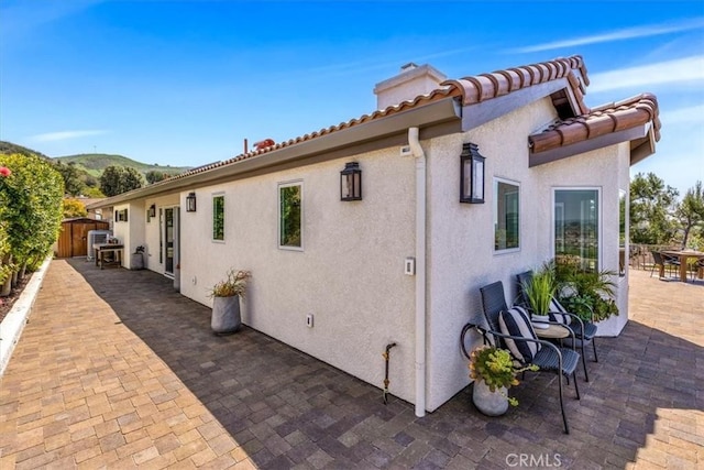 27553 Via Fortuna, San Juan Capistrano, CA 92675 - view of home's exterior with stucco siding, a mountain view, fence, and a patio