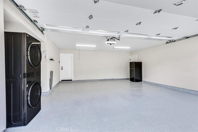 27553 Via Fortuna, San Juan Capistrano, CA 92675 - garage featuring a garage door opener, stacked washer / dryer, and baseboards