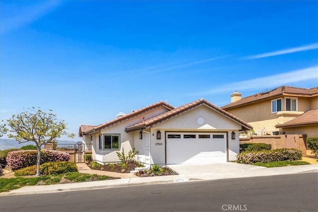 27553 Via Fortuna, San Juan Capistrano, CA 92675 - view of front facade with fence, concrete driveway, an attached garage, a tile roof, and stucco siding
