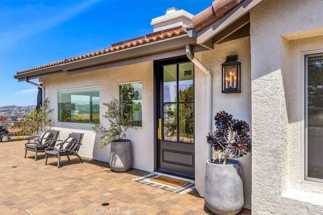 27553 Via Fortuna, San Juan Capistrano, CA 92675 - view of exterior entry with a patio, a tiled roof, and stucco siding
