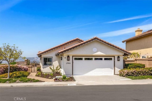 27553 Via Fortuna, San Juan Capistrano, CA 92675 - view of front of property featuring an attached garage, stucco siding, fence, and concrete driveway