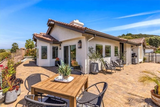 27553 Via Fortuna, San Juan Capistrano, CA 92675 - back of house with a patio area, a chimney, a tiled roof, a fenced backyard, and stucco siding