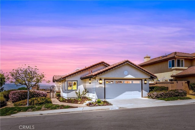 27553 Via Fortuna, San Juan Capistrano, CA 92675 - view of front of house with fence, stucco siding, an attached garage, a tile roof, and concrete driveway